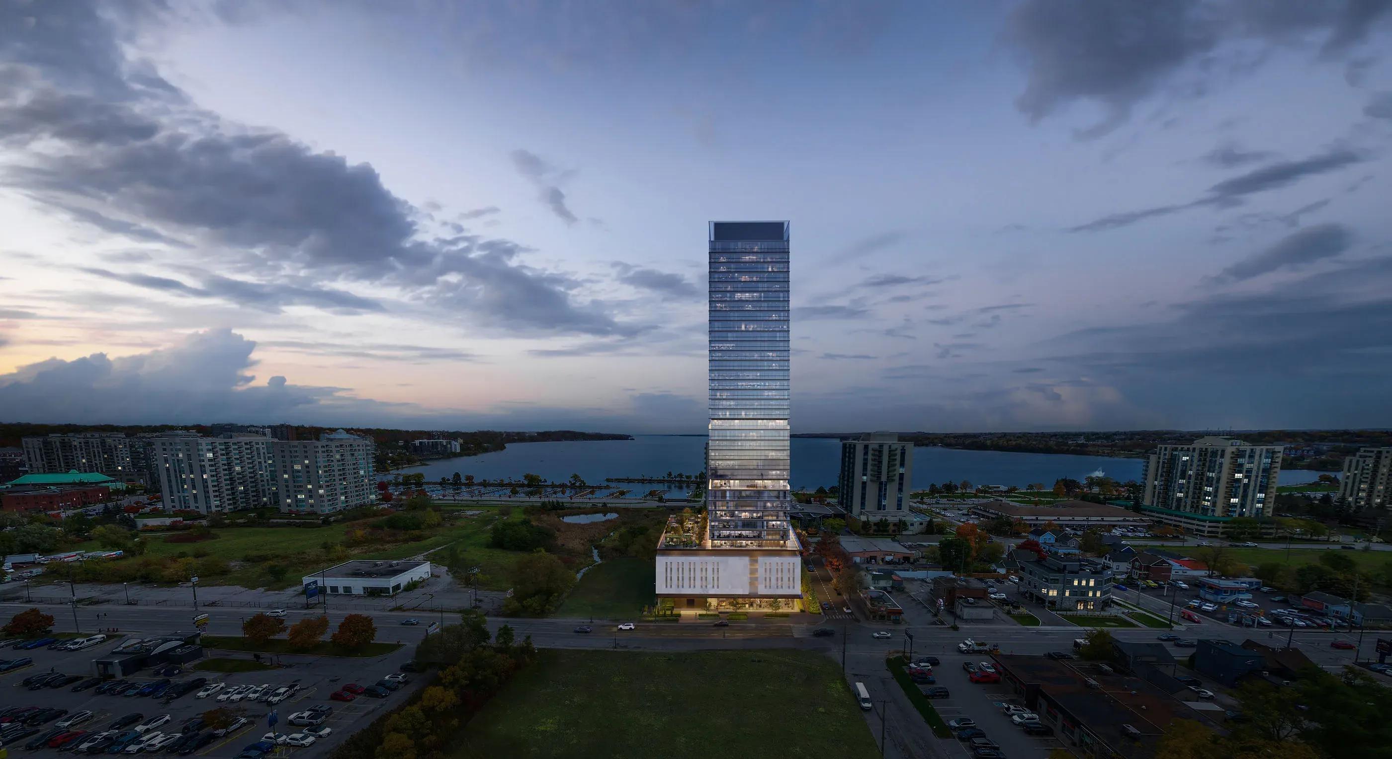 Frontal dusk view of a glass tower centered between lake and city, glowing podium